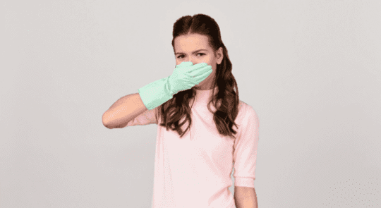 woman with latex glove holding hand over nose and mouth