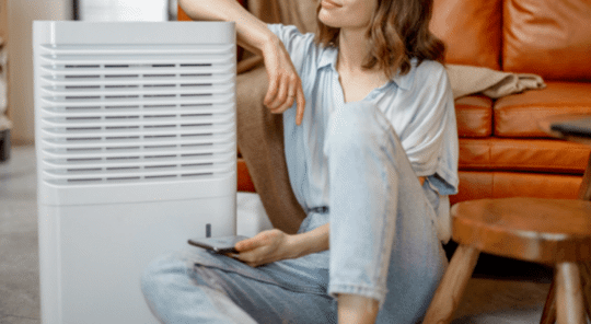 woman sitting by an air purifier