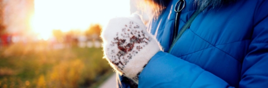 A person with winter gloves outside