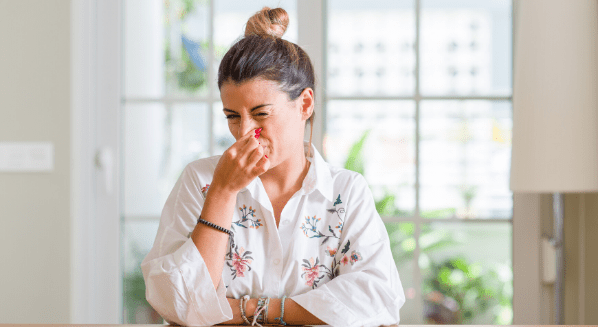 woman covering her nose from the bad smell