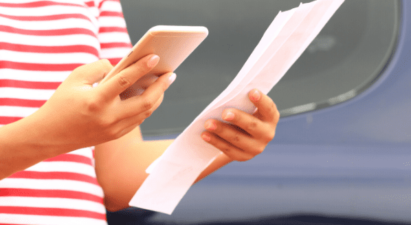 woman holding phone and utility bill