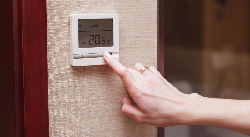 Person Adjusting the Thermostat
