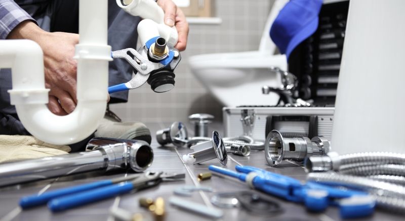 Technician Looking at Pieces of a Toilet